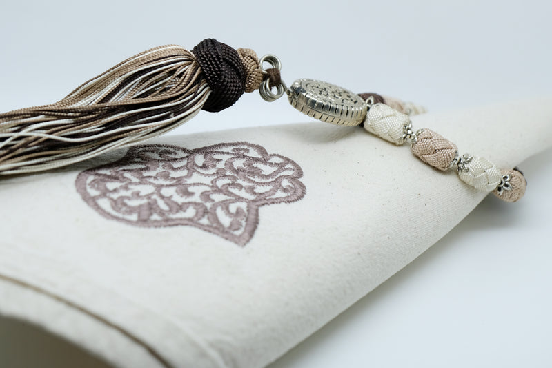 SET OF SIX BROWN & BEIGE EMBROIDERED NAPKINS AND TASSEL RINGS
