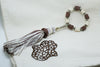 SET OF FOUR BROWN & CREAM EMBROIDERED NAPKINS AND BEADED TASSEL RINGS