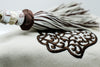 SET OF FOUR BROWN & CREAM EMBROIDERED NAPKINS AND BEADED TASSEL RINGS
