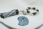 SET OF SIX GREY & CREAM EMBROIDERED NAPKINS AND BEADED TASSEL RINGS