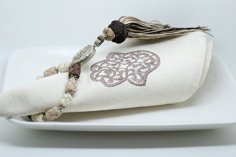 SET OF SIX BROWN & BEIGE EMBROIDERED NAPKINS AND TASSEL RINGS